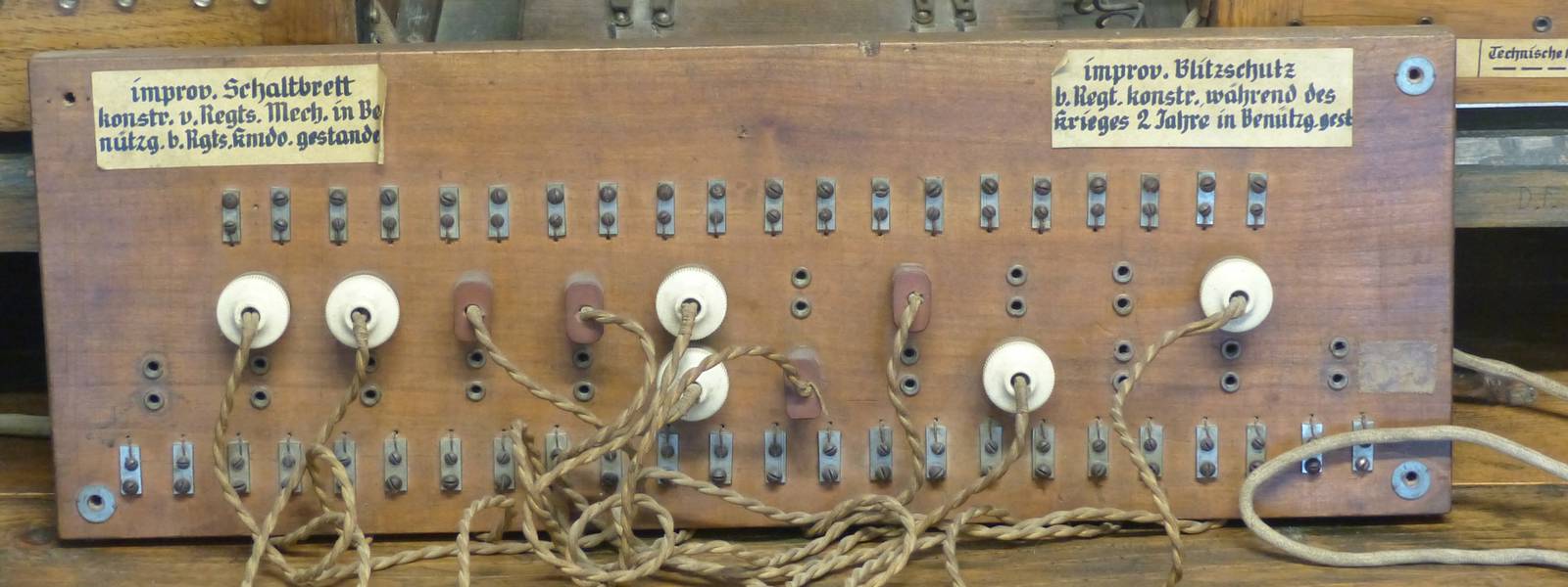 Vintage wooden switchboard with multiple buttons and wires.